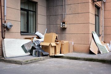 A large dump of construction waste near the entrance to a residential building.