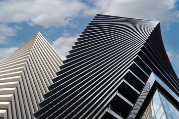 Close-up of a modern glass office building. Reflection of the sky with clouds in the glass of the building.