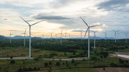 Wind turbines stand tall against a backdrop of cloudy skies, scattered across the expansive field. renewable energy.