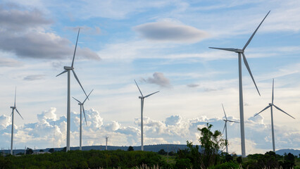 Wind turbines stand tall against a backdrop of cloudy skies, scattered across the expansive field. renewable energy.