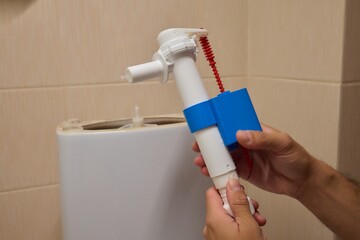 Hands skillfully Installing a Toilet Fill Valve in the Bathroom for Water Efficiency