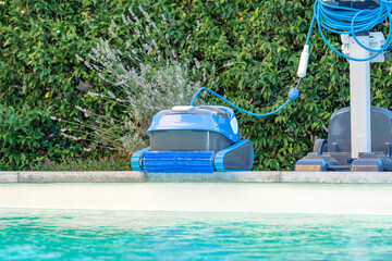 Automatic Pool Cleaner by the Poolside with Garden Background