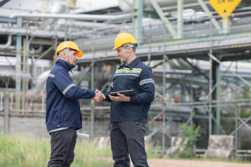 Petroleum engineers having a handshake at oil refinery site