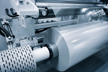 Automatic polyethylene plastic bag production machine with lighting effect. Close-up of the roller of the plastic bag production machine in the light blue scene. product packaging concept