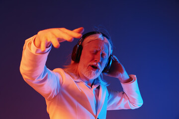 elderly man enjoying music, wearing headphones, colorful background, emotional expression, dancing...