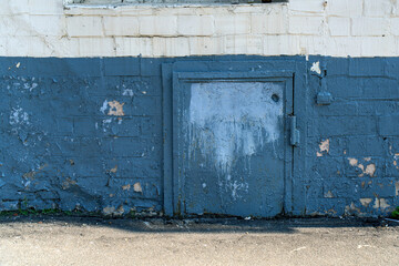 basement door, now obstructed by asphalt, symbolizes forgotten access and hidden spaces, highlighting the contrast between urban development and neglected history