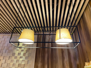 Two beautifully designed lamps are hanging from a wooden ceiling