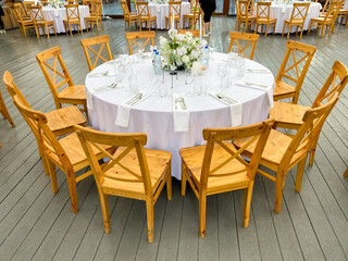 An elegant round dining table set designed specifically for events, featuring a charming floral...