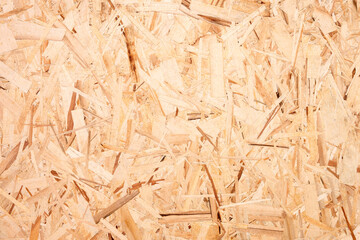 A pile of wood chips with a brownish colortexture background. The pile is made up of small pieces of wood