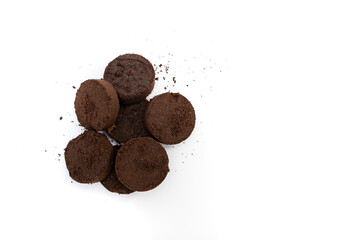 Dry coffee puck from espresso machine, isolated on white background, flat lay close up
