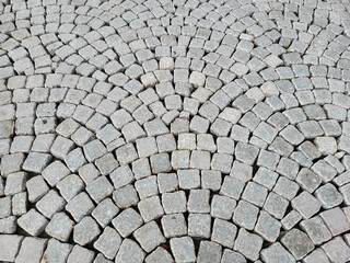The sidewalk is lined with paving stones in a semicircular pattern