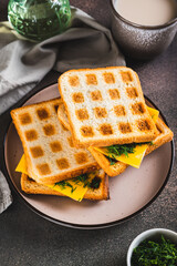 Morning waffle toast with melted cheese on a plate on the table vertical view