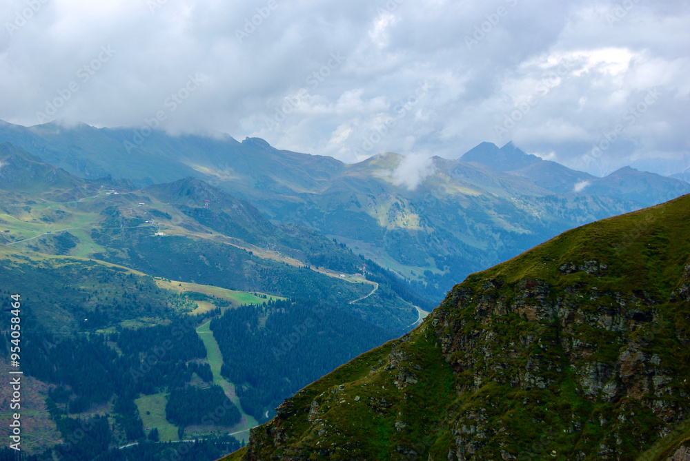Wall mural view of an amazing mountain landscape on a hazy day with gray clouds and fog over the peaks in autum