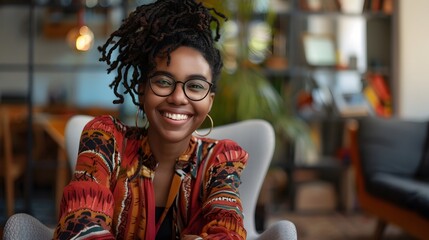 happy young african american young woman sitting in her chair smiling.