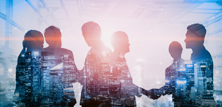 Double exposure image of many business people conference group meeting on city office building in background showing partnership success of business deal. Concept of teamwork, trust and agreement. uds