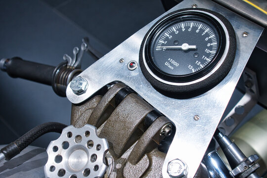 Das minimalistische Cockpit eines &auml;lteren Rennmotorrads mit einem spartanischen Drehzahlmesser strahlt puren Rennsport und Nervenkitzel aus