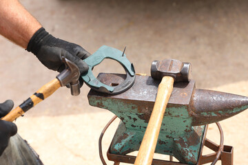 Farrier tools close up view at rural horse farm. Equestrian life. Equipments and hammer rest on the...