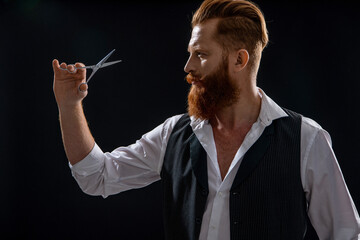 Handsome hairstylist with haircut. Barbershop. Man hairdressing and barbering. Hairdresser at barbershop isolated on black. Hairdresser man. Professional barber man hold scissors