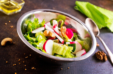 A salad of fresh organic radish, cucumber with dill and green onions dressed with oil