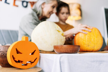 Family carving pumpkins for halloween celebration at home, selective focus