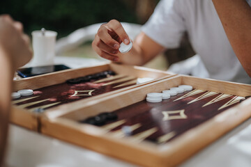 Casual backgammon game between friends in outdoor setting