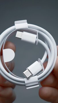 Close-up of type C wire for charging phone. Action. Type-C connector for charging phone on isolated ofn. New wire type C and included for phone