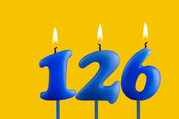 Blue birthday candle on yellow background - Number 126