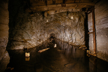Dark flooded concrete vaulted mine tunnel