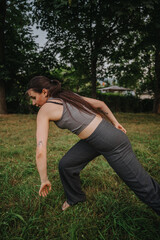 A young woman gracefully performs a dance in a tranquil park, embodying movement and freedom in a...