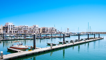 Agadir Marina in Morocco. Popular tourist area with luxury apartments, boats in harbor, shops and...