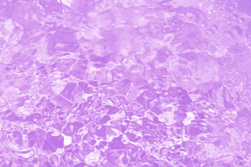 Fototapeta premium Pink water bubbles on the surface ripples. Defocus blurred transparent pink colored clear calm water surface texture with splash and bubbles. Water waves with shining pattern texture background