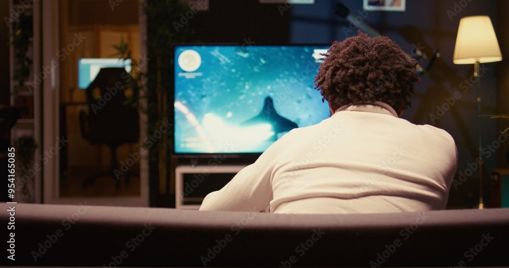 Poster man in neon lit apartment using cloud gaming service to play demanding sf videogame on tv. player en