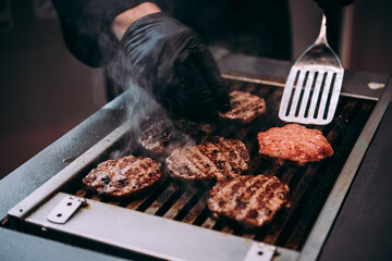 Grilling meat patties for classic burger in a cafe of a restaurant.