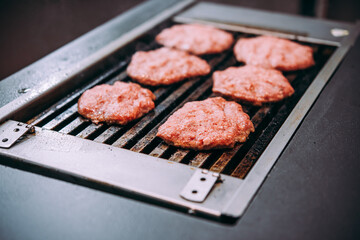 Grilling meat patties for classic burger in a cafe of a restaurant.