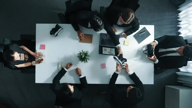 Top view of professional businessman give vr headset to diverse investors while young businesswoman looking at data analysis or marketing statistic on laptop and prepare for data sharing. Directorate. - Powered by Adobe