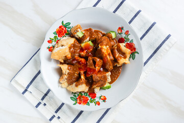 Batagor,(Fried Tofu Meatballs), served on a serving plate with peanut sauce, sambal, and chili sauce. This is authentic street food from Bandung Indonesia. Perfect for recipes, articles or any cooking