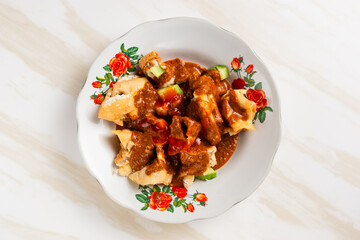 Batagor,(Fried Tofu Meatballs), served on a serving plate with peanut sauce, sambal, and chili sauce. This is authentic street food from Bandung Indonesia. Perfect for recipes, articles or any cooking