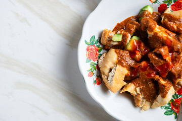 Batagor,(Fried Tofu Meatballs), served on a serving plate with peanut sauce, sambal, and chili sauce. This is authentic street food from Bandung Indonesia. Perfect for recipes, articles or any cooking