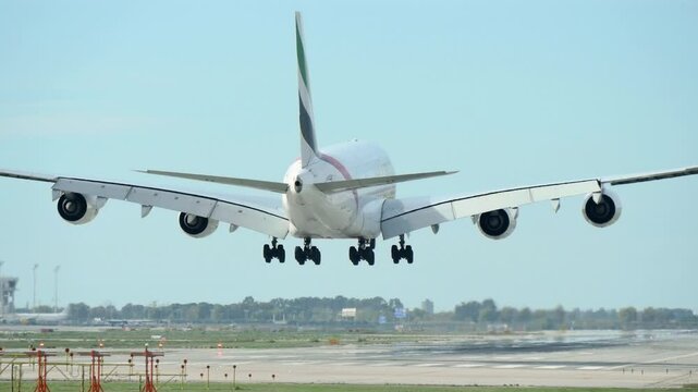 Airbus A380 Landing on Runway: Rear View. A powerful Airbus A380 captured from behind as it gracefully touches down on the runway after a long flight
