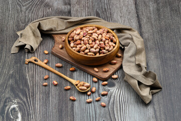red kidney beans in wooden bowl isolated on dark background.