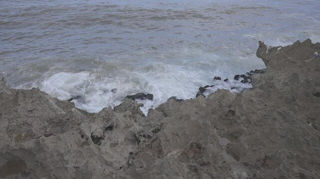 view of ocean waves crashing against rugged coastal rocks, video raw c-log 8bits