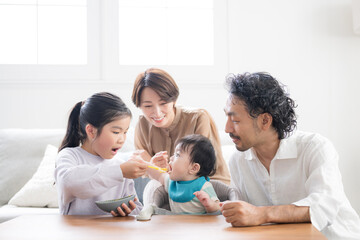 Fototapeta premium 赤ちゃんに離乳食をあげる家族