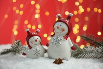 Cute decorative snowmen, anise star and fir branches on artificial snow
