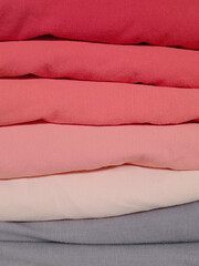 Stack of folded clean clothes in gradient colors.