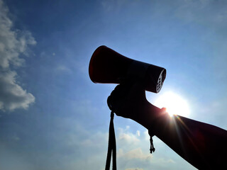 silhouette of hand holding megaphone. protest concept
