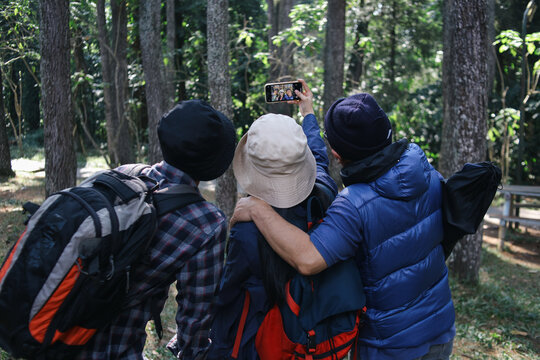 Asian Family Taking Selfie Walking In Forest