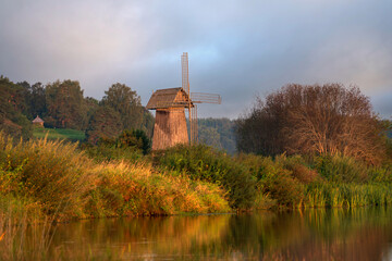 View of an ancient wooden windmill on the banks of the Sorot River on a foggy summer morning,...