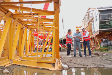 Fototapeta premium Team of workers at construction site with heavy machines.