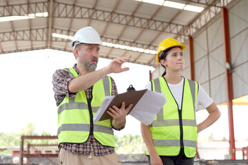 Team of workers at construction site with heavy machines.
