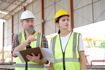 Team of workers at construction site with heavy machines.
